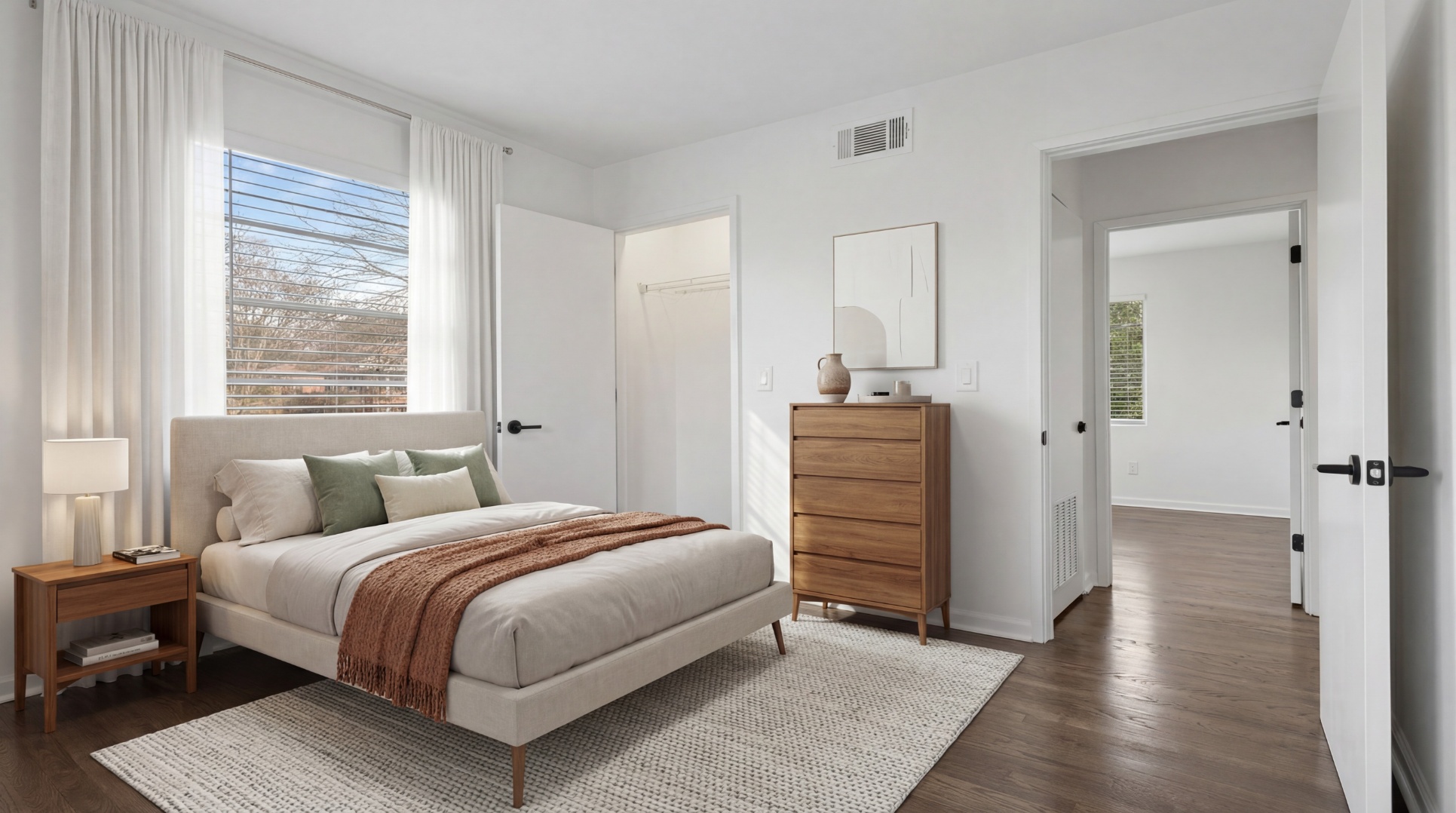 Spacious bedroom with ample natural lighting and wood-style flooring